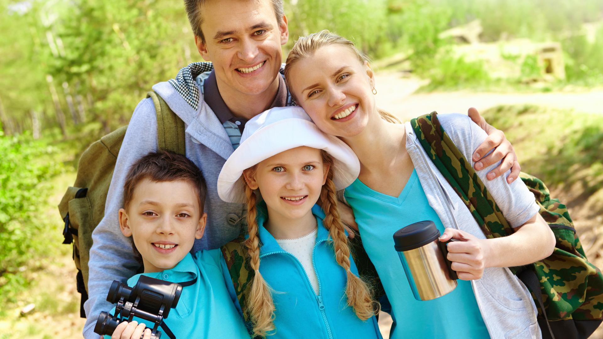 Portrait of family of travelers looking at camera in summer