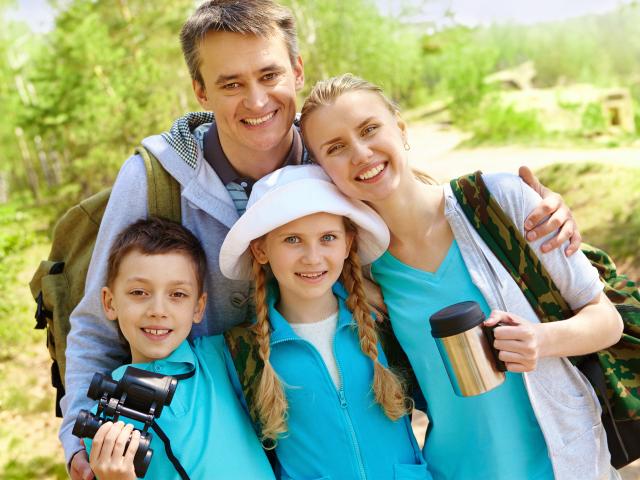 Portrait of family of travelers looking at camera in summer
