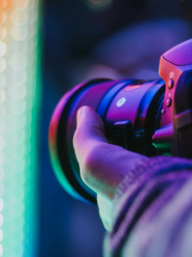 Un appareil photo tenu dans une main devant une lumière